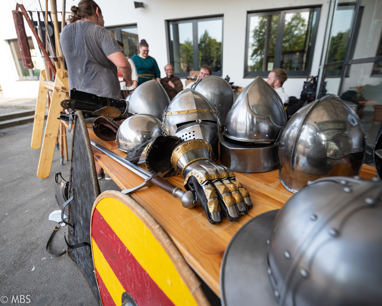 Gestapelte mittelalterliche Helme, Handschuhe und andere Rüstungsbestandteile